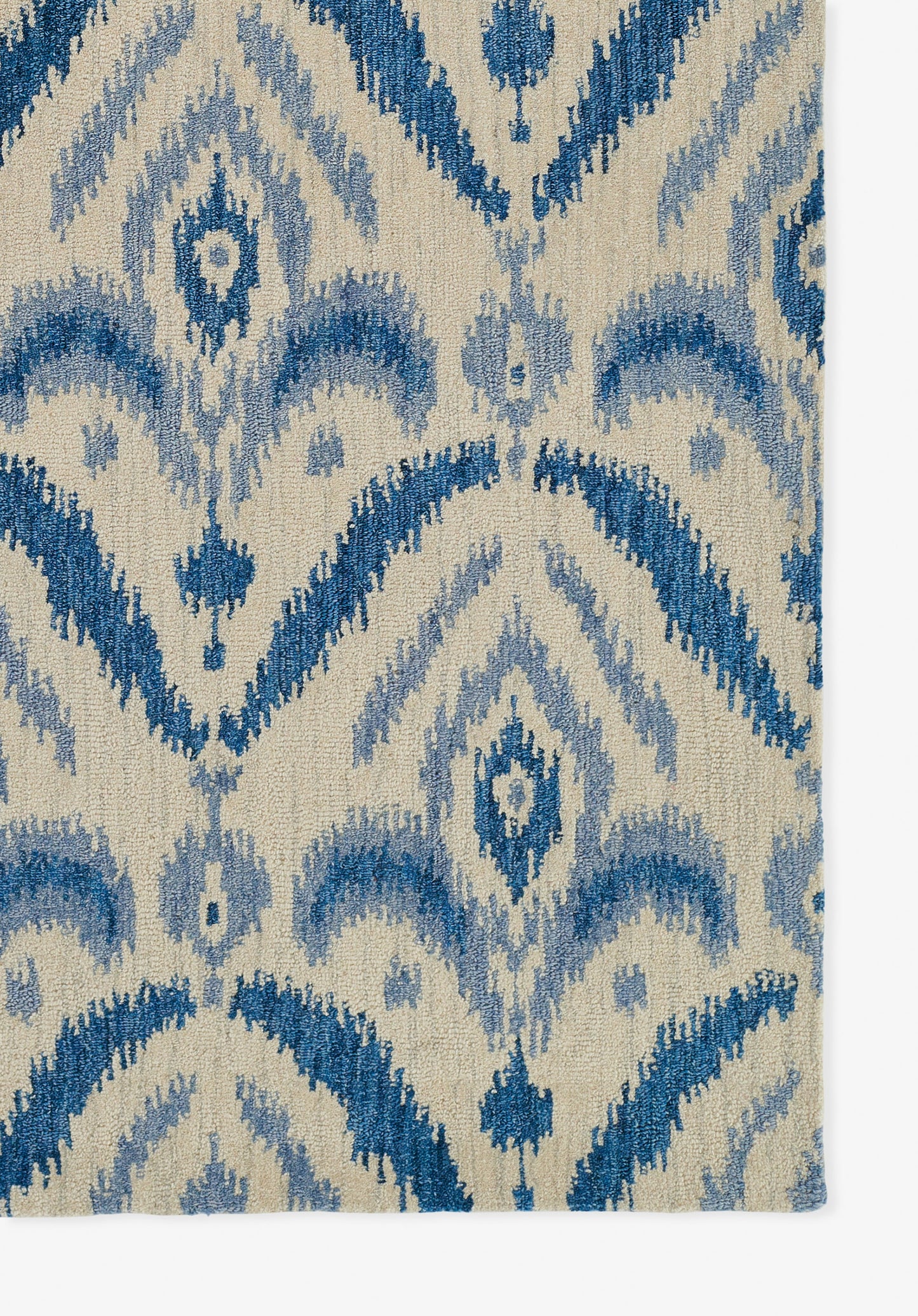 Beige rug with blue ikat pattern and diamond motifs; woven texture.