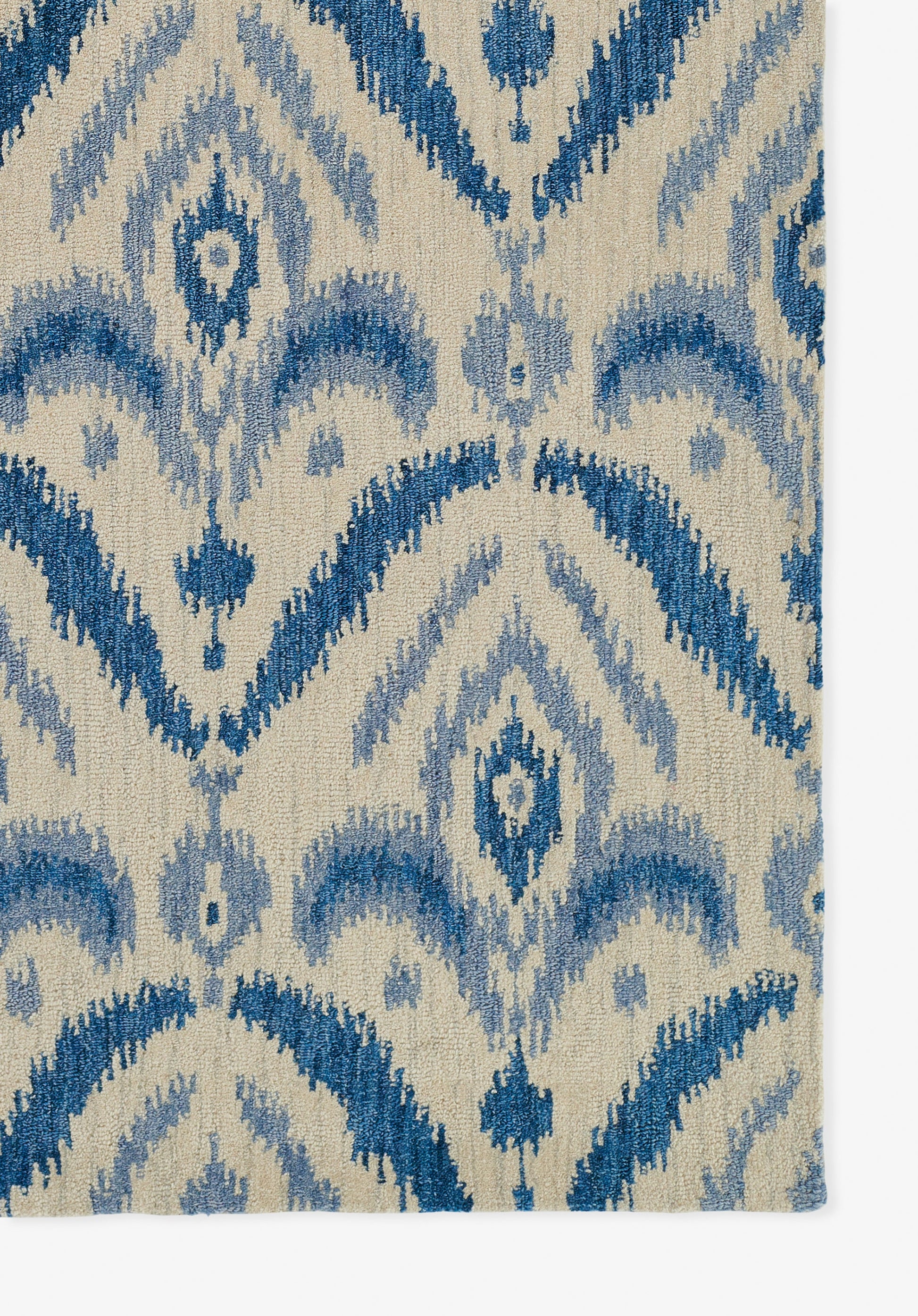 Blue ikat-style rug with a beige background; woven texture, navy and light blue geometric motifs.