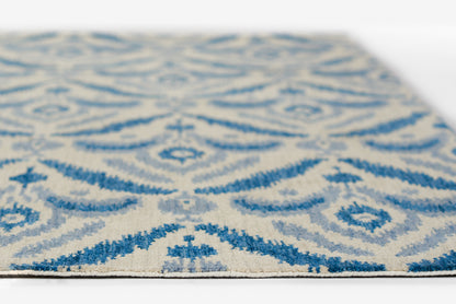 Blue and ivory patterned rug with scrolling arabesque motifs, woven texture, rectangular shape, edge visible.