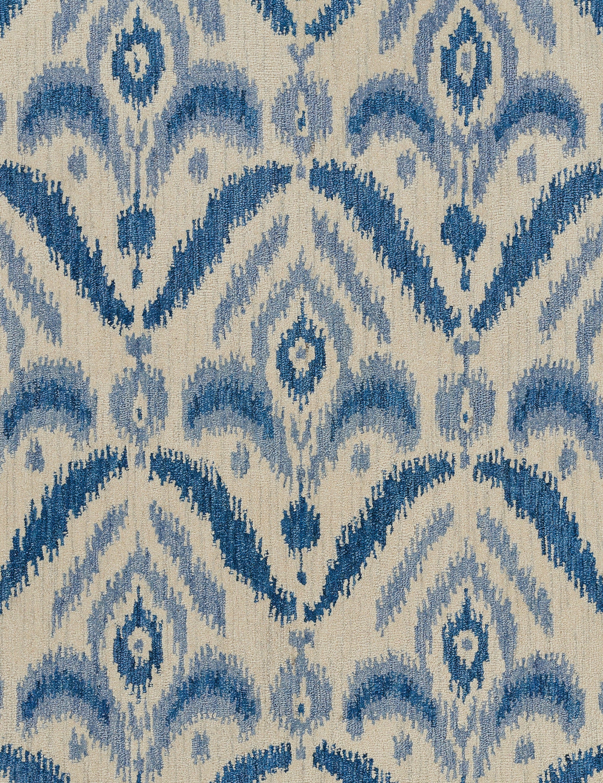 Beige woven textile with blue ikat-inspired chevron and diamond motifs.