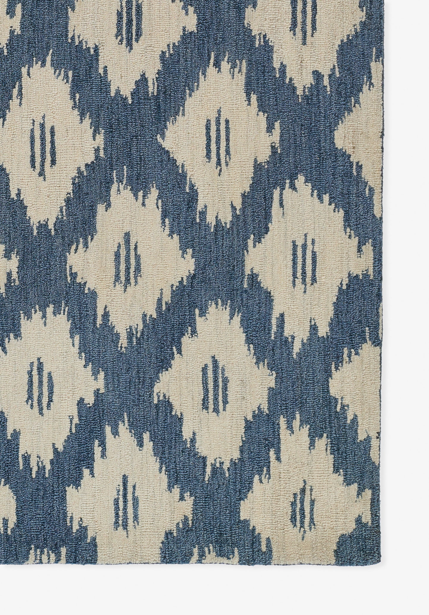 Blue and cream ikat diamond-pattern rug with woven texture.