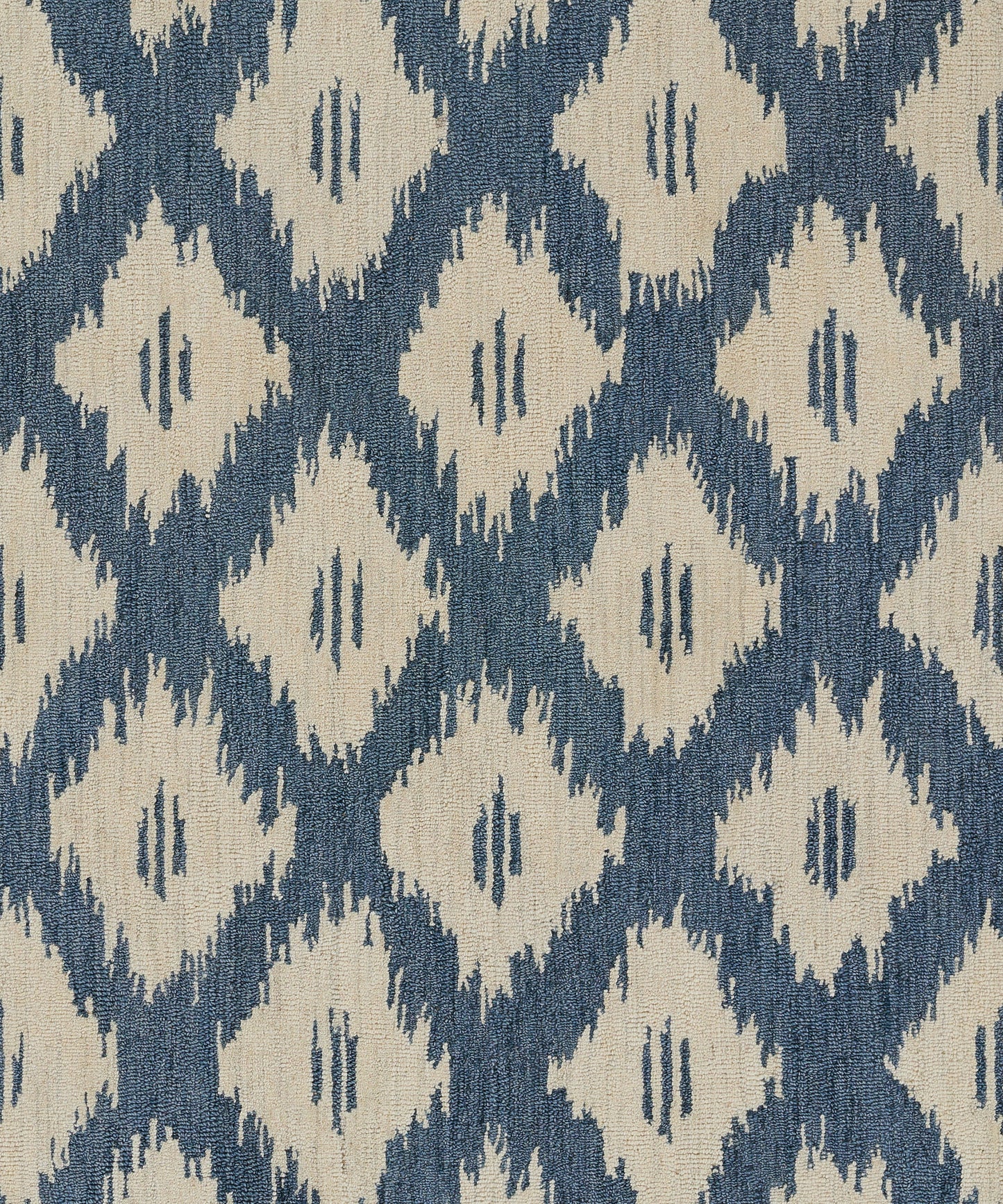 Blue background with beige diamond ikat pattern; woven rug fabric.