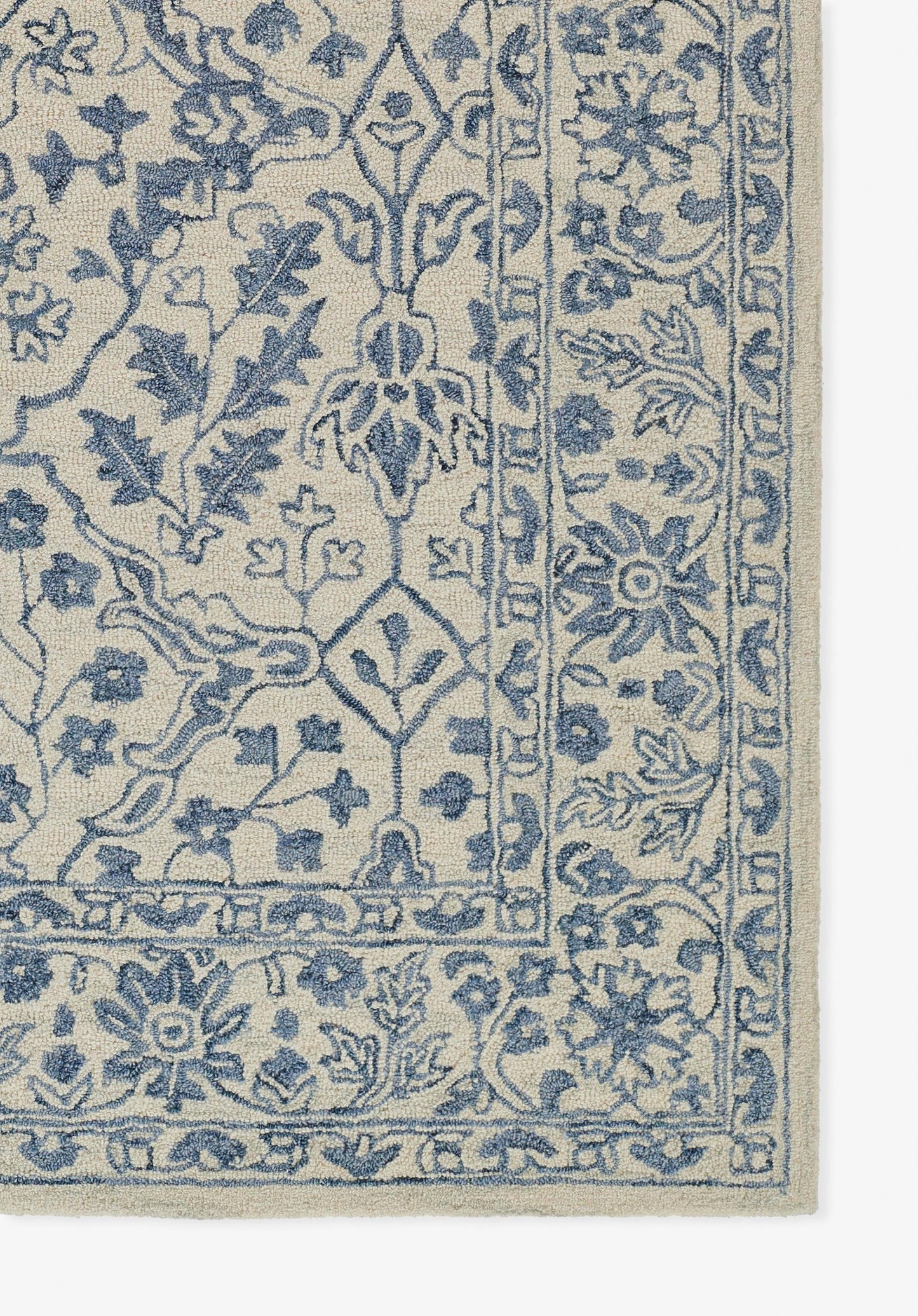 Beige area rug with blue intricate floral oriental pattern and bordered edge.
