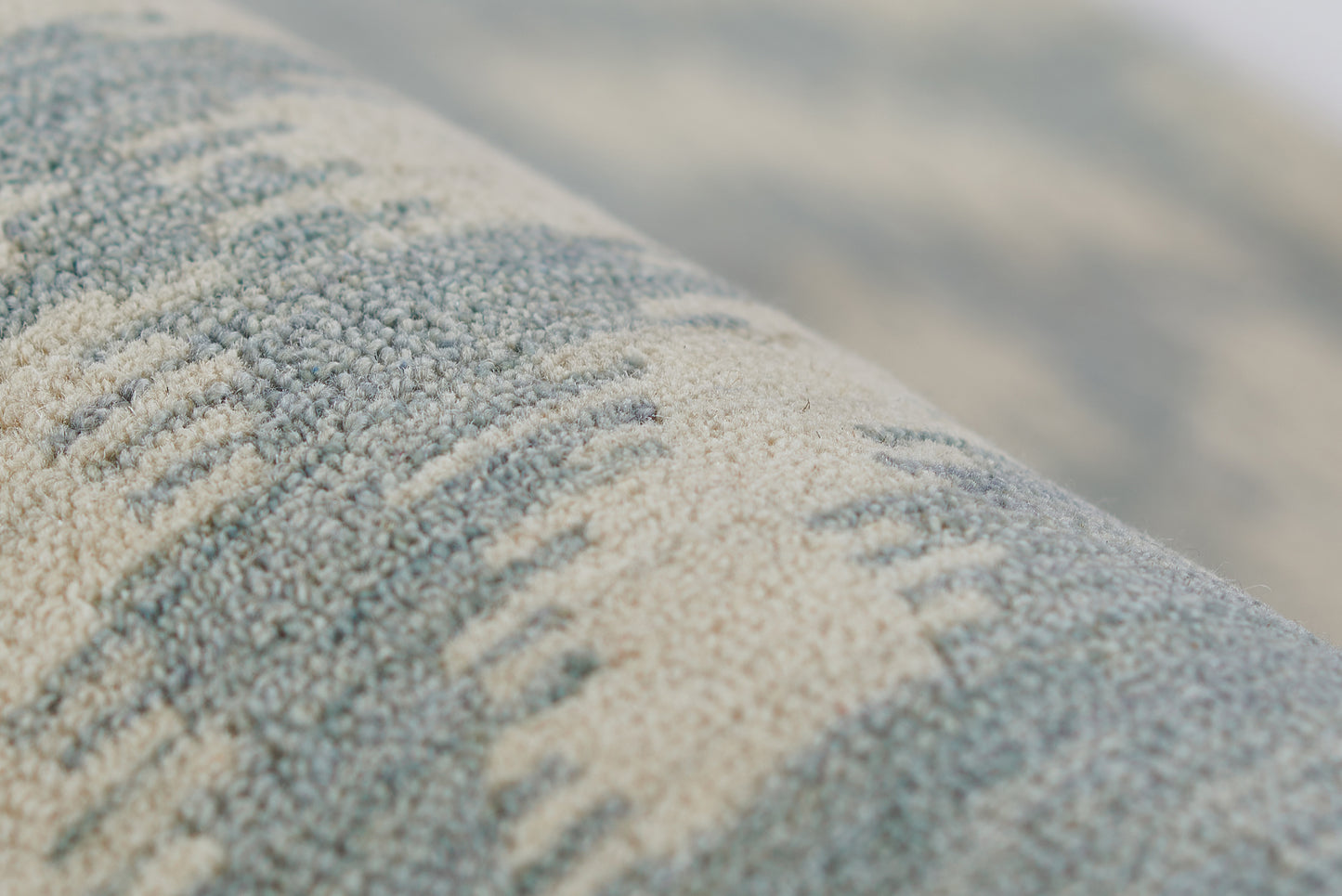 Close-up of blue and beige boucle rug with raised textured stripes.