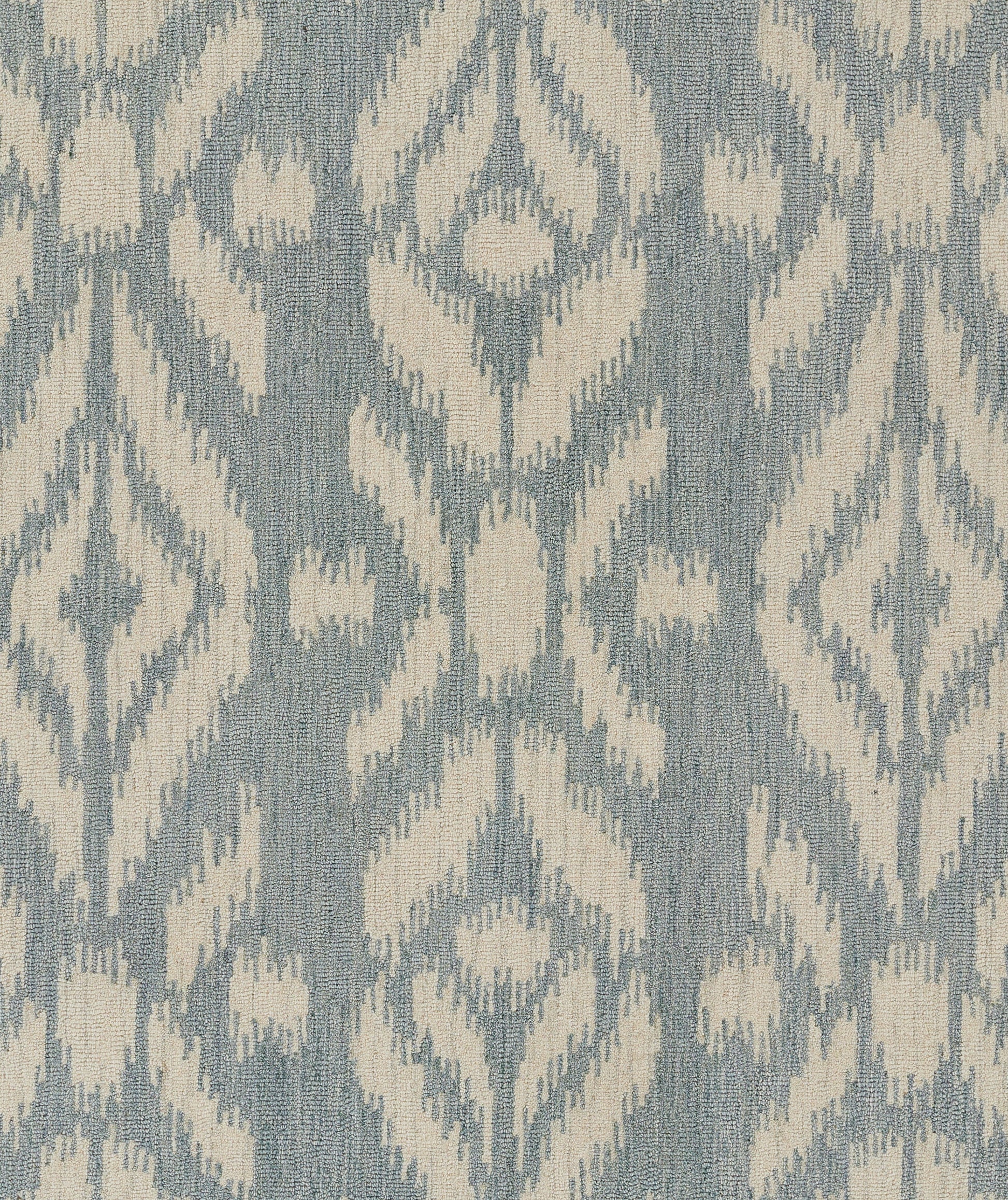 Blue-gray woven rug with ivory ikat-inspired geometric pattern; decorative 5' x 8' rug.