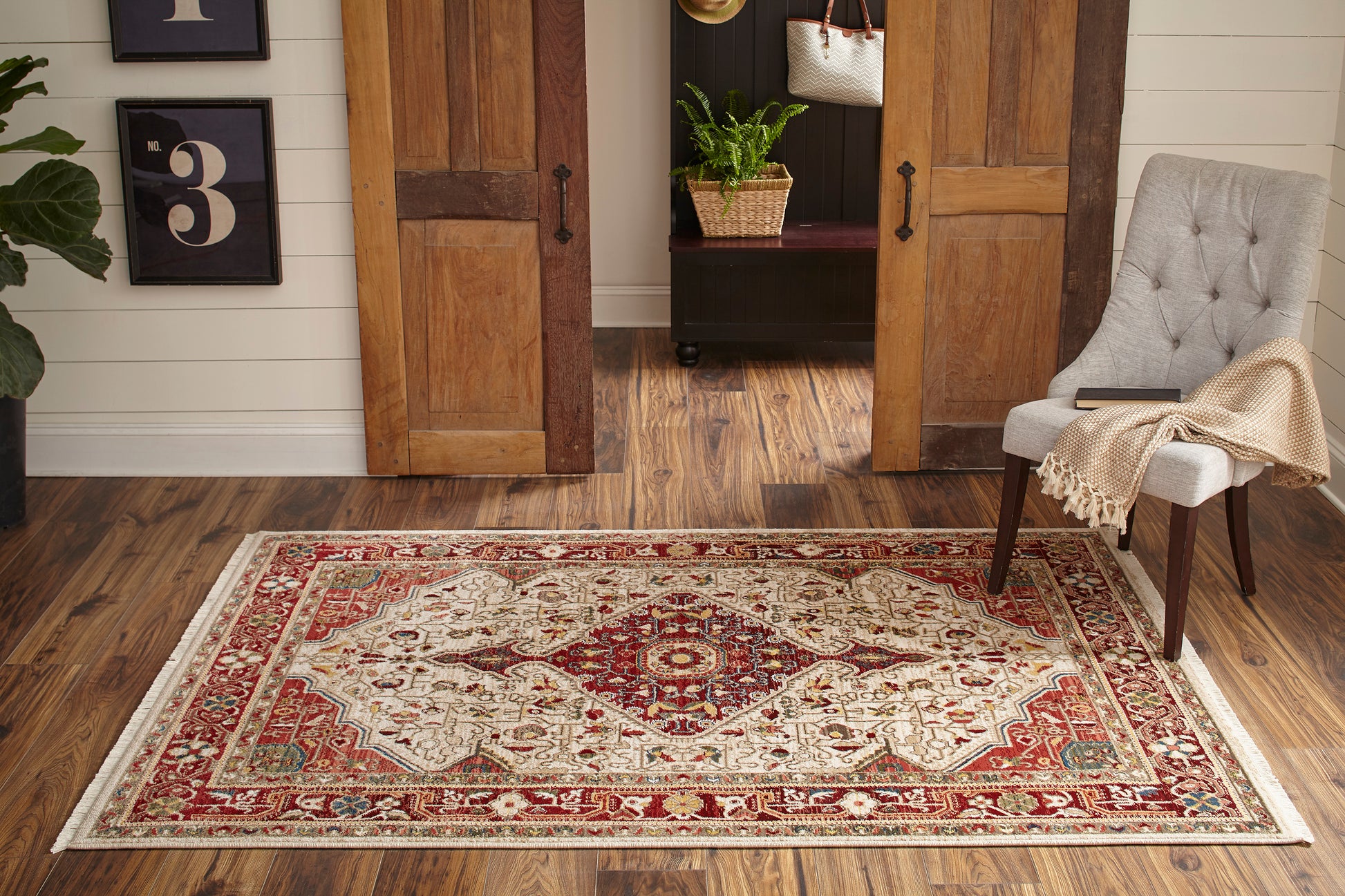 Rectangular oriental-style runner in red, ivory and teal with a floral medallion and ornate border on a wood floor.