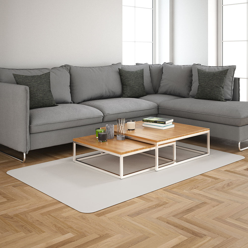 Light-grey sectional sofa with dark cushions, two-tier wood-and-metal coffee table on a pale rug.
