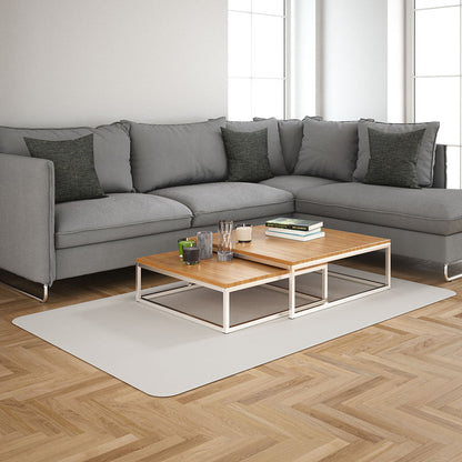 Light-grey sectional sofa with dark cushions, two-tier wood-and-metal coffee table on a pale rug.