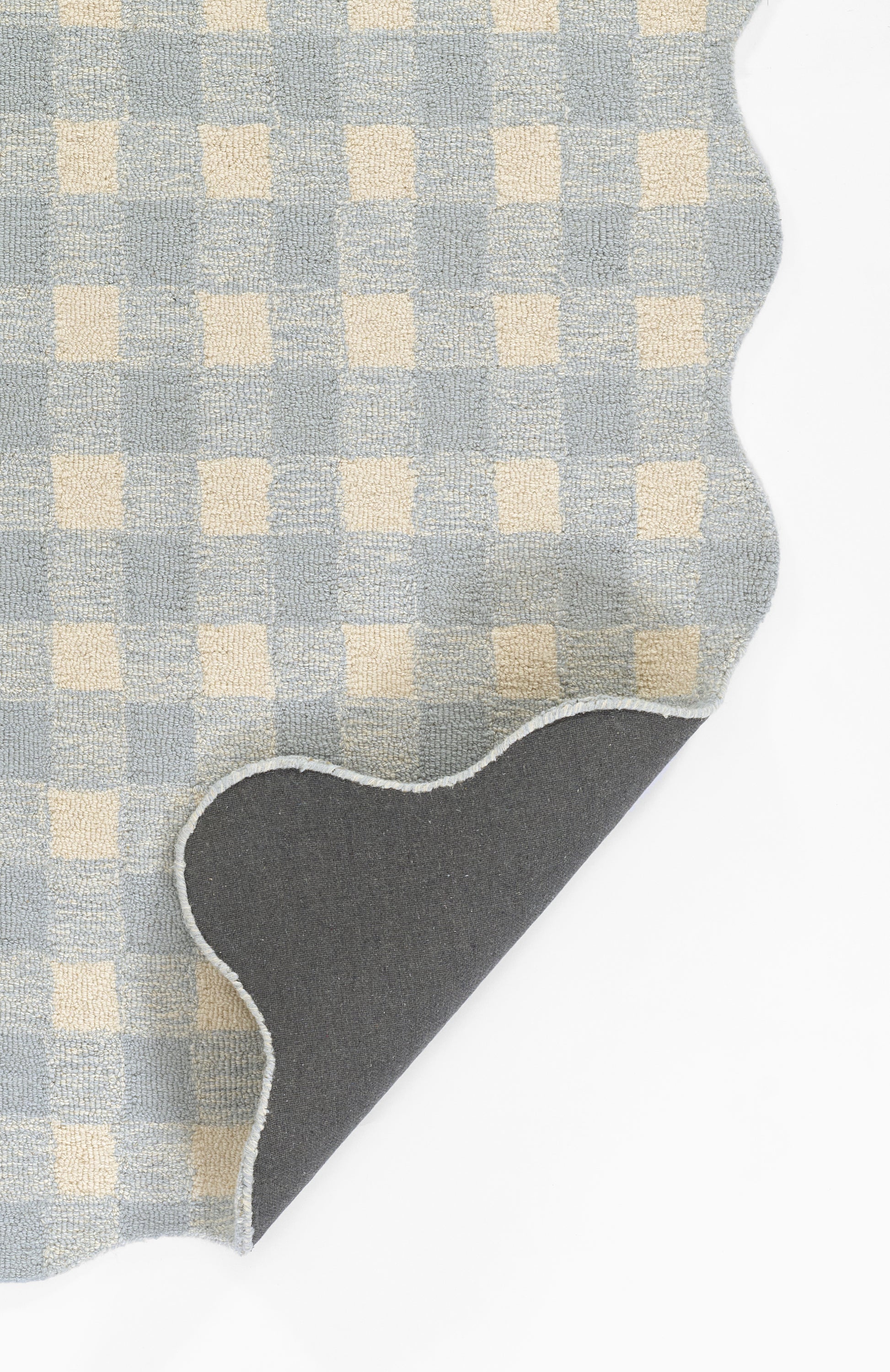 Blue and cream checkered rug with a scalloped curved edge and grey reverse.