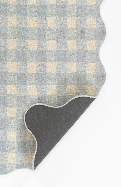Blue and cream gingham rug with a scalloped curved edge, folded to reveal a gray underside.