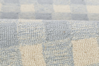 Soft blue and cream checkered woven textile with boucle texture, suitable as rug or throw.
