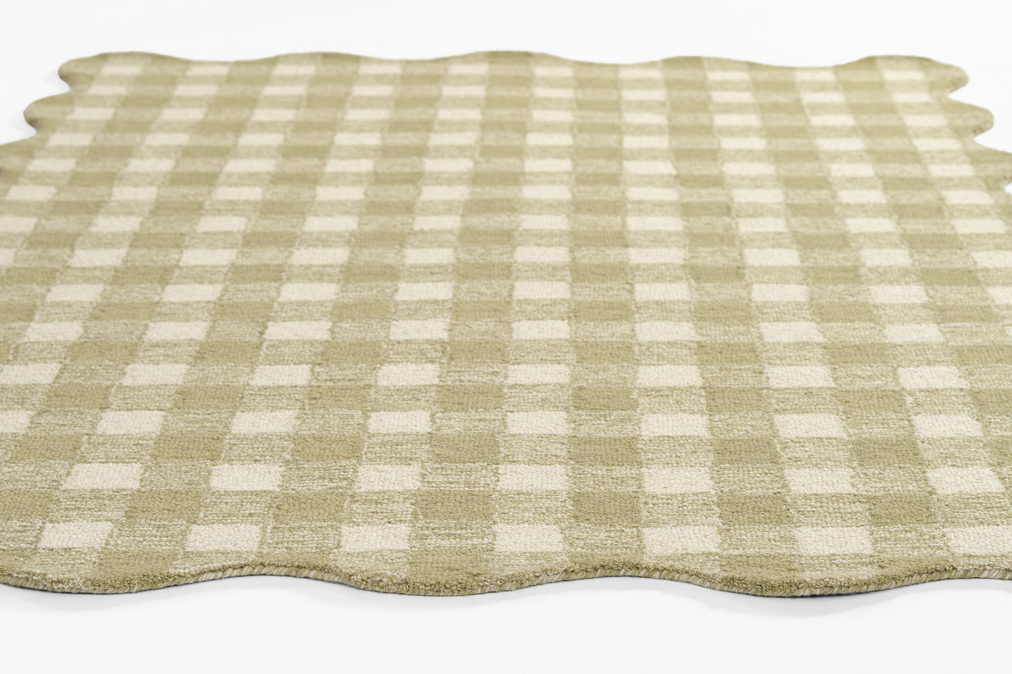 Beige and white gingham area rug with scalloped edges.