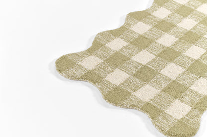 Sage green and cream gingham round rug with scalloped edges and soft textured pile.