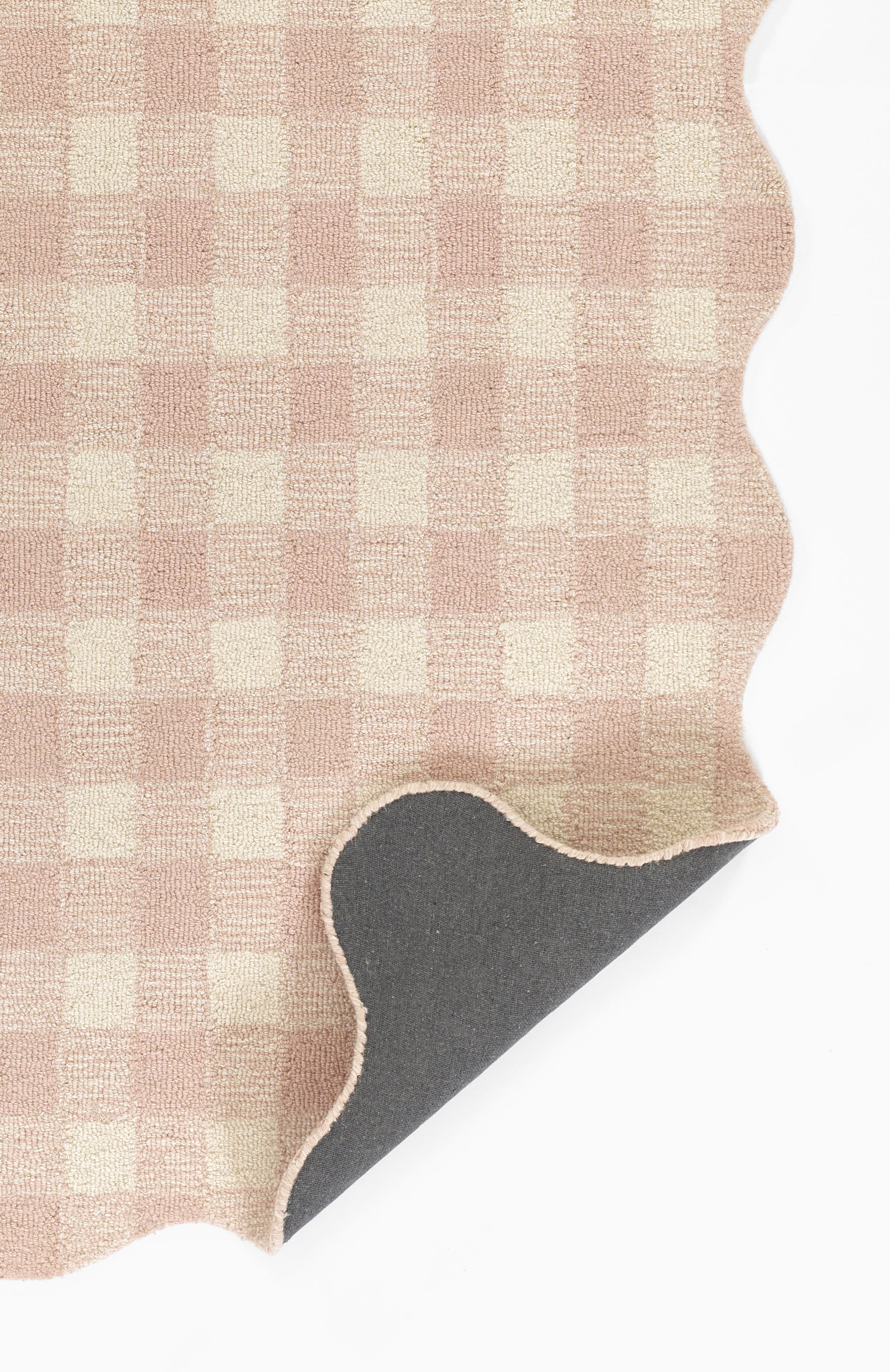 Beige-pink gingham rug in a 2' x 3' size with a scalloped edge and grey backing.