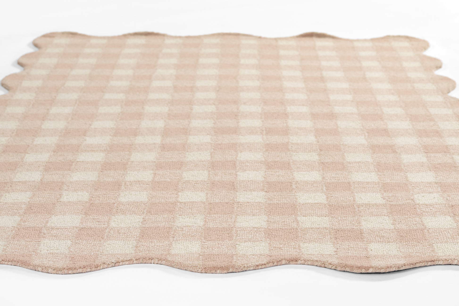 Pink gingham placemat with scalloped edges, cotton fabric, flat-lay dining accessory.
