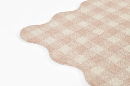 Pink-beige gingham rug with a scalloped edge and soft plush pile.