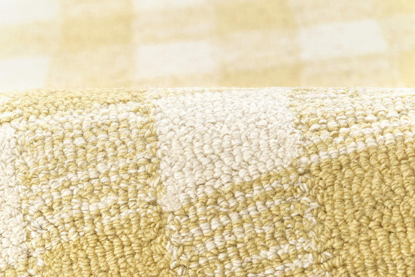 Close-up of yellow and cream plaid rug with soft looped pile texture.