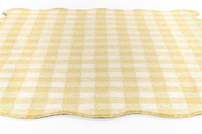 Yellow and white gingham rug with a wavy bottom edge.