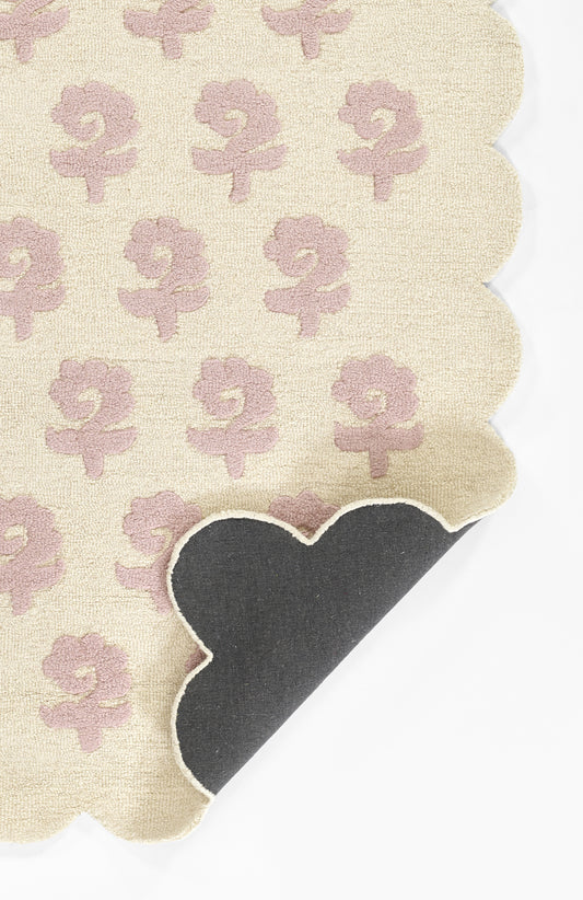 Beige linen napkin with pale pink lily floral pattern, scalloped edges, white stitch detail; decorative table setting.