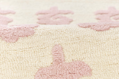 Cream bath mat with pale pink floral pattern, plush terry weave and cozy look.