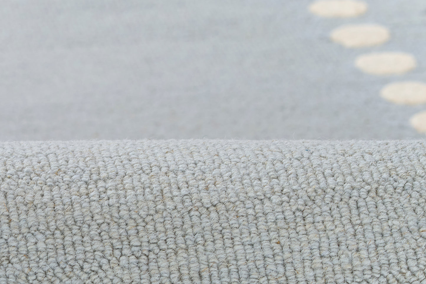 Light blue-gray loop-pile rug with tiny beige dot accents and soft textured surface, ideal for living rooms.
