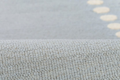 Light blue-gray loop-pile rug with tiny beige dot accents and soft textured surface, ideal for living rooms.