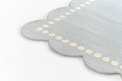 Light blue scalloped rug with a cream dotted border along the edge.