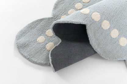 Soft blue rug with cream polka dot border; cozy underfoot for living room or bedroom.