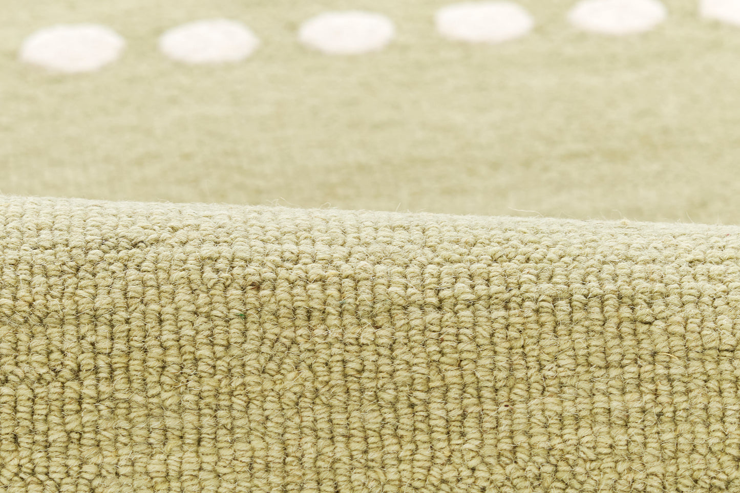 Beige-green loop-pile rug with a white dotted border along the edge; soft textured home decor.