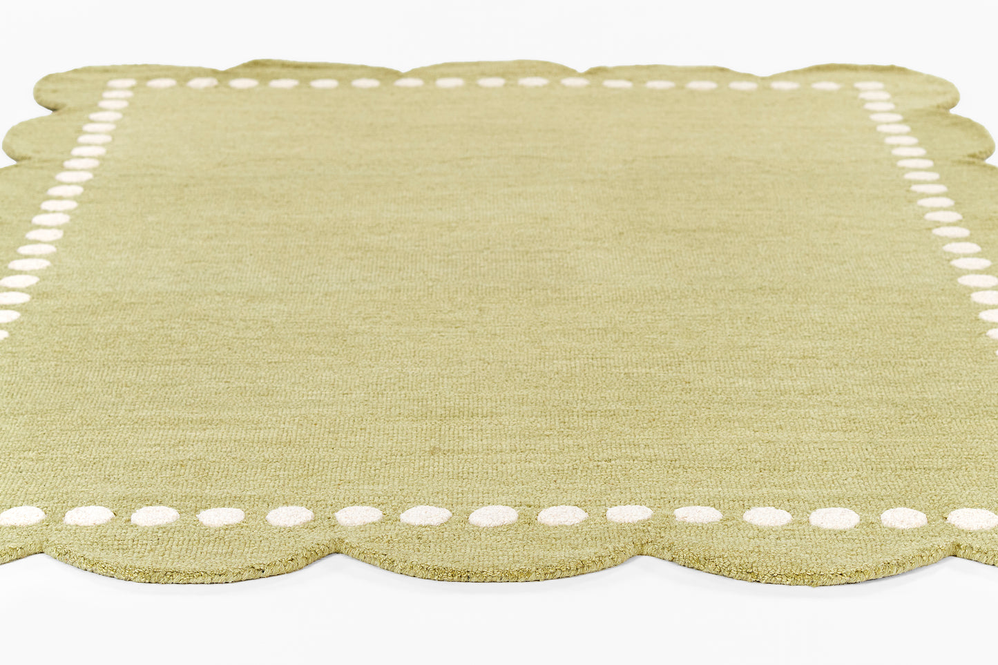 Olive-green linen placemat with scalloped bottom edge and white dotted border.