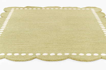 Olive-green linen placemat with scalloped bottom edge and white dotted border.