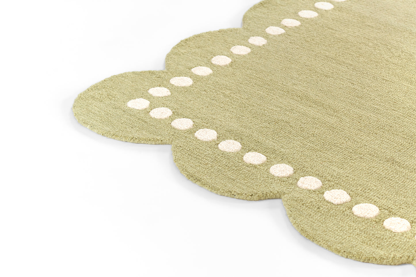 Beige rug with scalloped edge and white dot stitching; textured jute-like fiber.