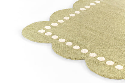 Beige-green natural-fiber mat with scalloped edges and white dot border; decorative entry rug.