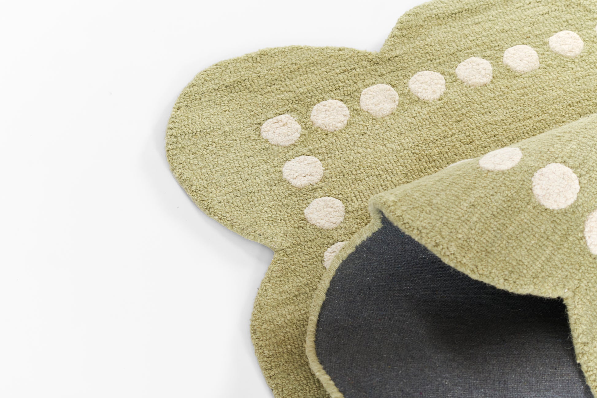 Green rug with white polka dots; plush texture, 8' x 10'.