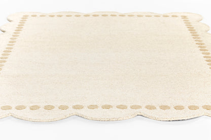 Cream woven rug runner with scalloped edges and a dotted border, 2' x 8'.