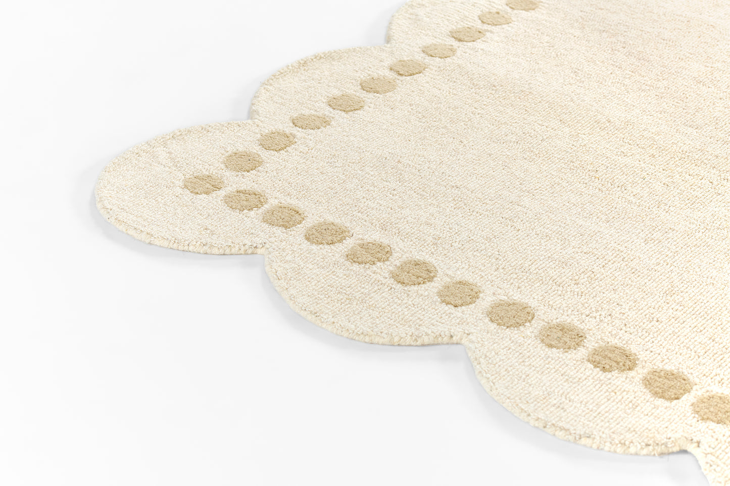 Beige plush runner rug with scalloped edges and dotted border.