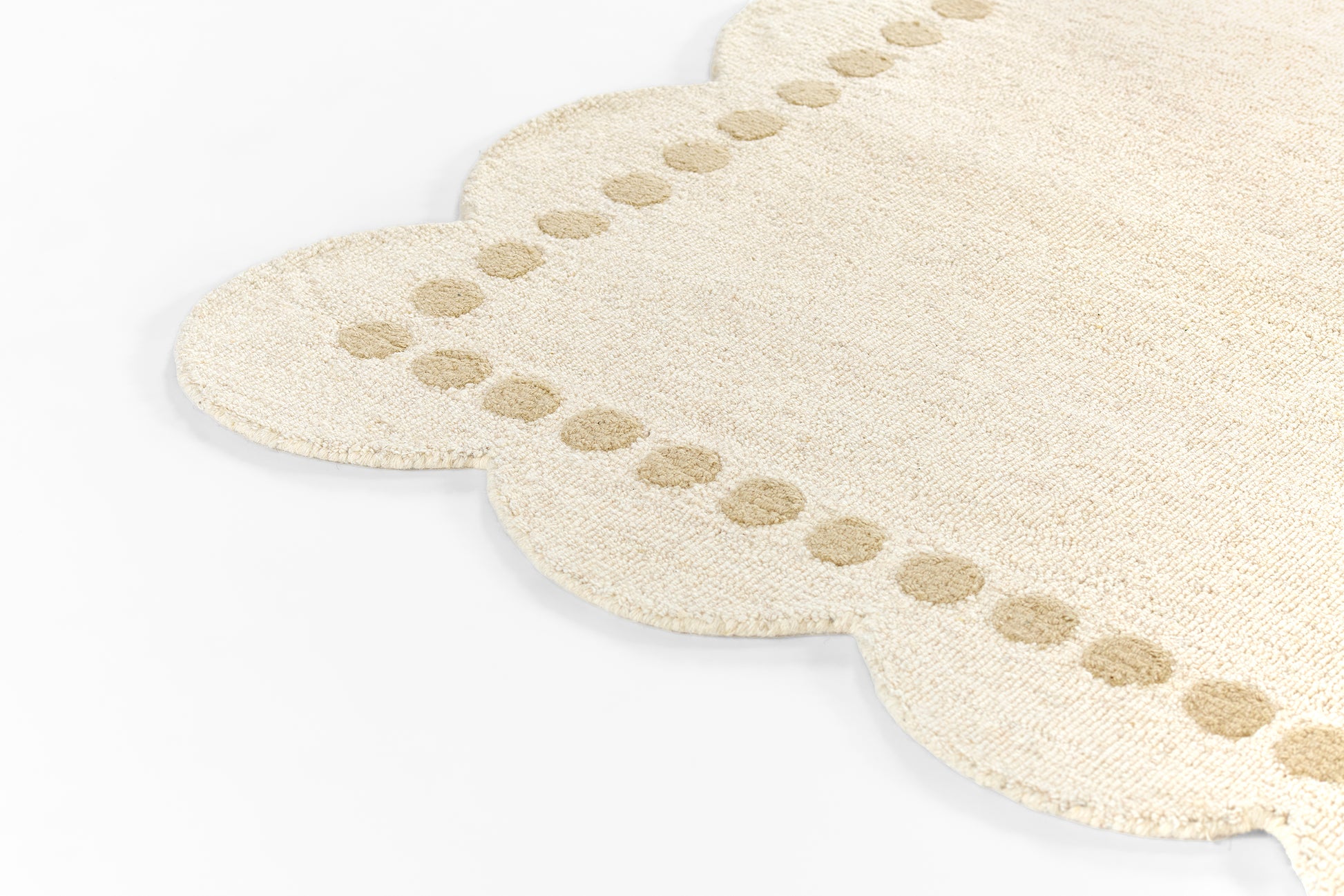 Beige plush runner rug with scalloped edges and dotted border.