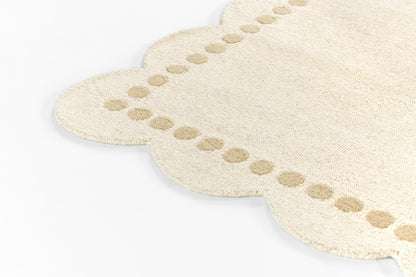 Beige plush runner rug with scalloped edges and dotted border.