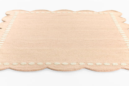Beige-peach woven rug runner, rectangular with scalloped edges and a stitched border; 2' x 8'.