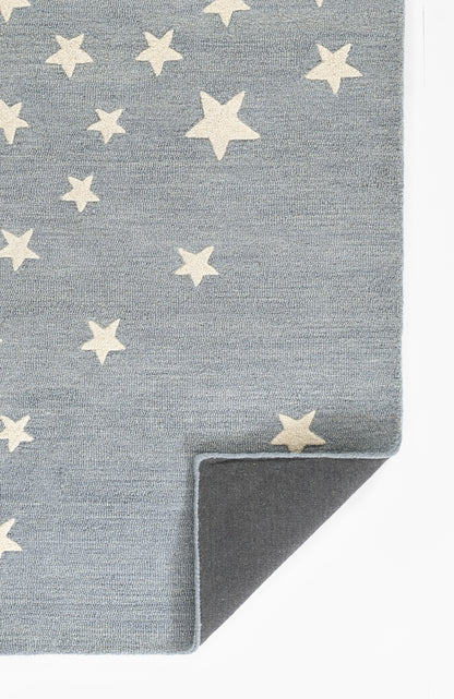 Blue-grey rug with cream-white star pattern, folded corner showing dark underside.