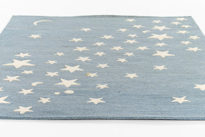 Blue round rug with white stars scattered across & a crescent moon motif, soft woven texture.