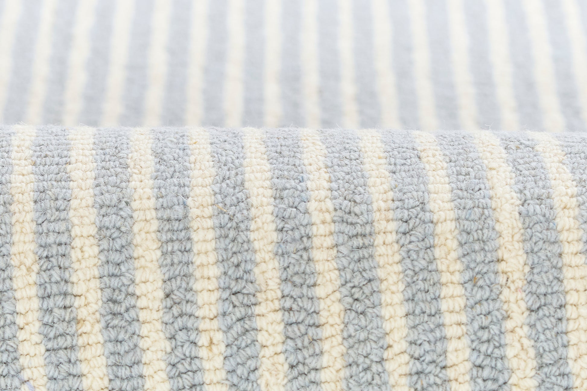 Close-up of pale blue and cream striped terry cloth fabric with textured loops; towel or bath textile.