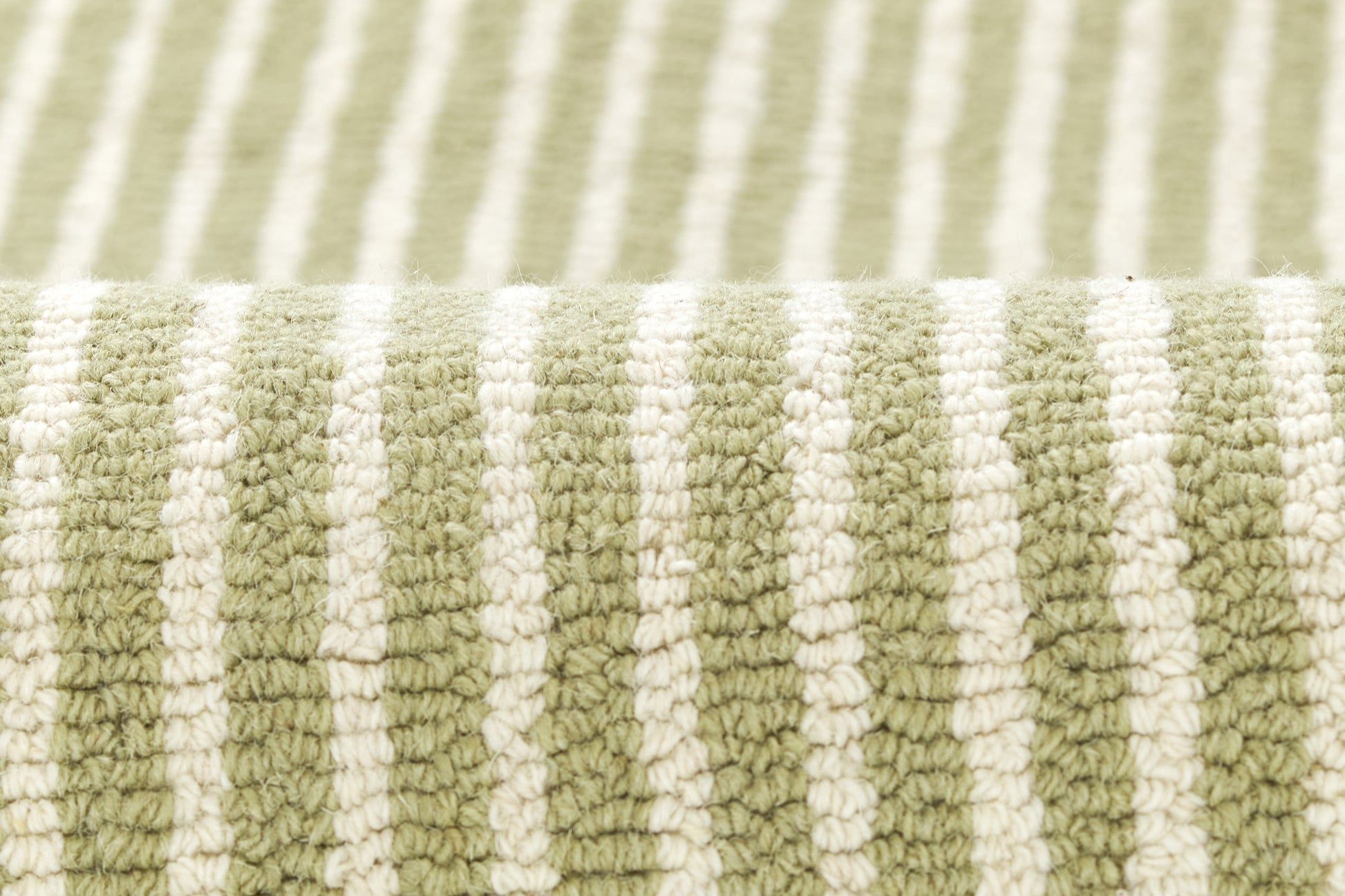 Close-up of sage green and cream striped plush rug with looped pile texture.