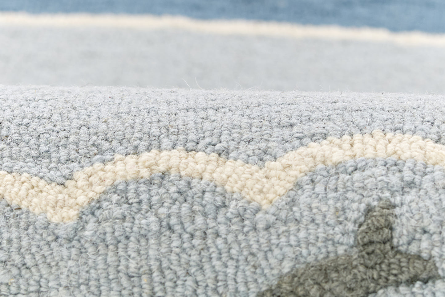 Blue-gray boucle rug with cream wavy stripe; plush textured pile for coastal living spaces.