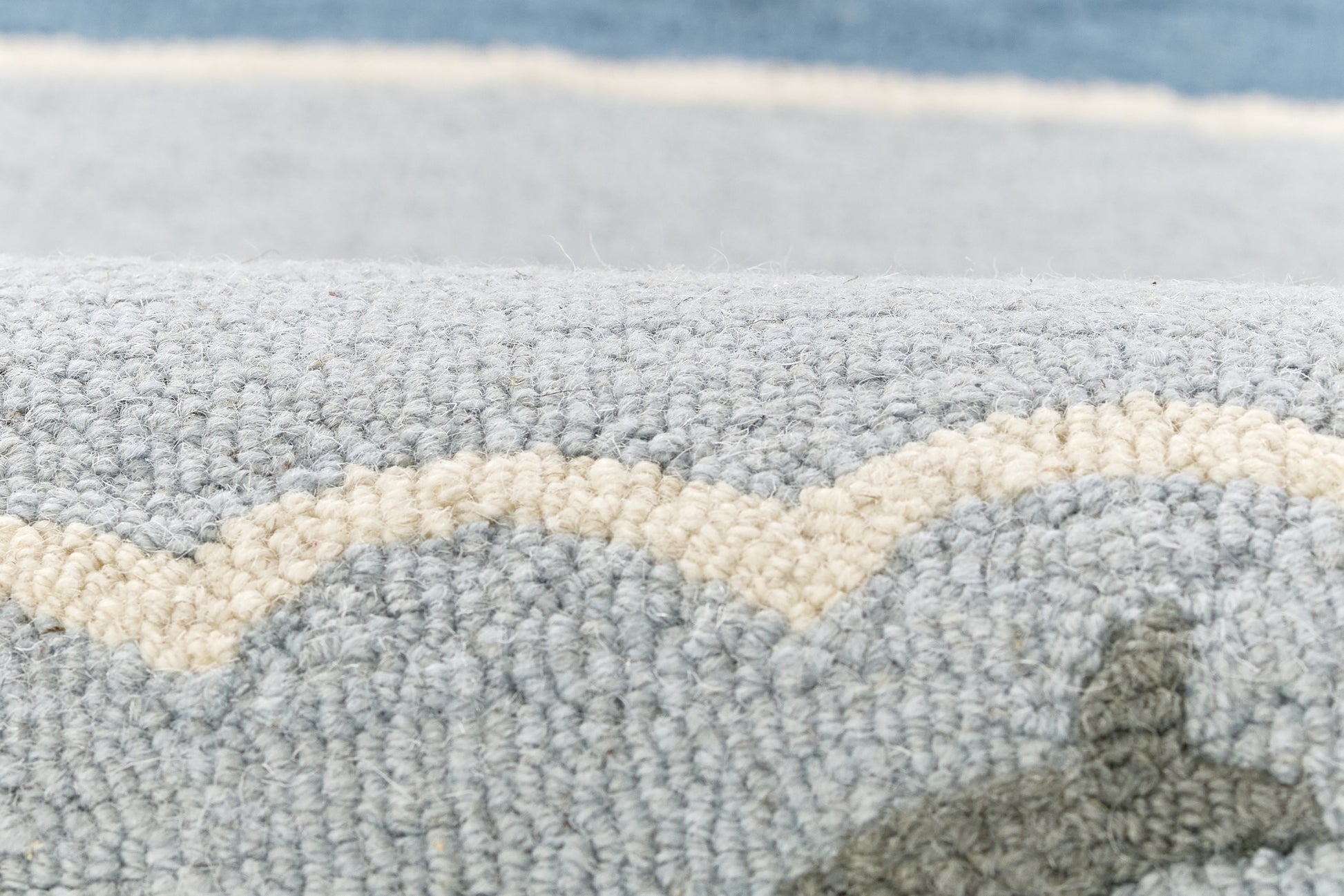 Blue-gray boucle rug with cream wavy stripe; plush textured pile for coastal living spaces.