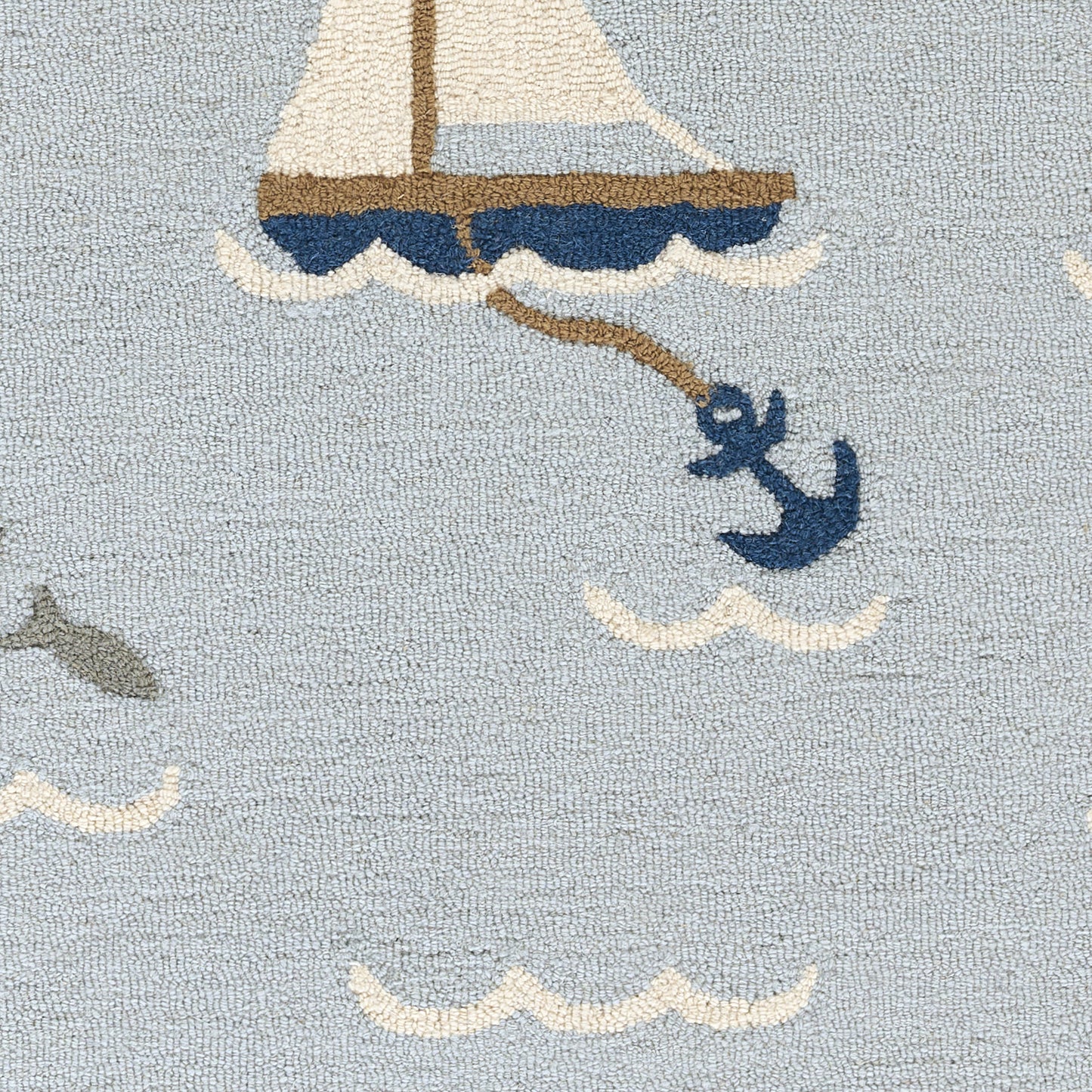 Coastal sailboat rug in pale blue with white sails, brown mast, navy hull, rope and wave motifs; small fish.