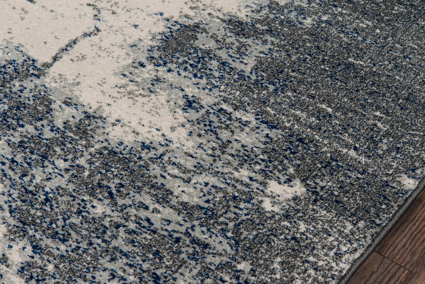 Abstract gray-blue speckled area rug with plush pile; modern style for living spaces.
