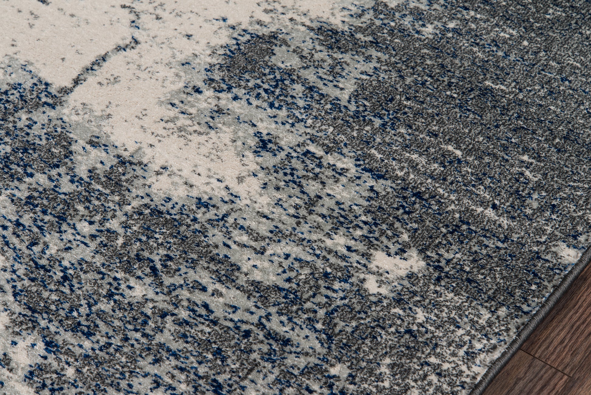 Abstract gray-blue speckled area rug with plush pile; modern style for living spaces.