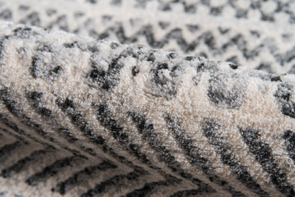 Close-up of a grey & ivory patterned rug with soft, looped pile and chevron zigzags.