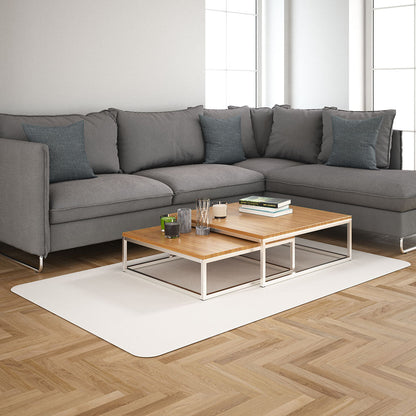 Modern gray L-shaped sofa with blue cushions and a light wood two-tier coffee table on a pale rug in a bright living room.